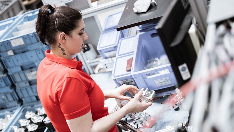 Mitarbeiterin bei der Montage von Pumpen für Standheizungen und Standheizungsgeräte.
