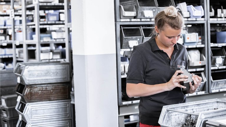 Mitarbeiterin mit einer Gerotorpumpe für die Waschmitteldosierung.