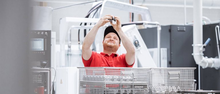 Bild eines Mitarbeiters von Scherzinger aus dem Bereich Maschinenbau Anlagenbau mit einer Zahnradpumpe.